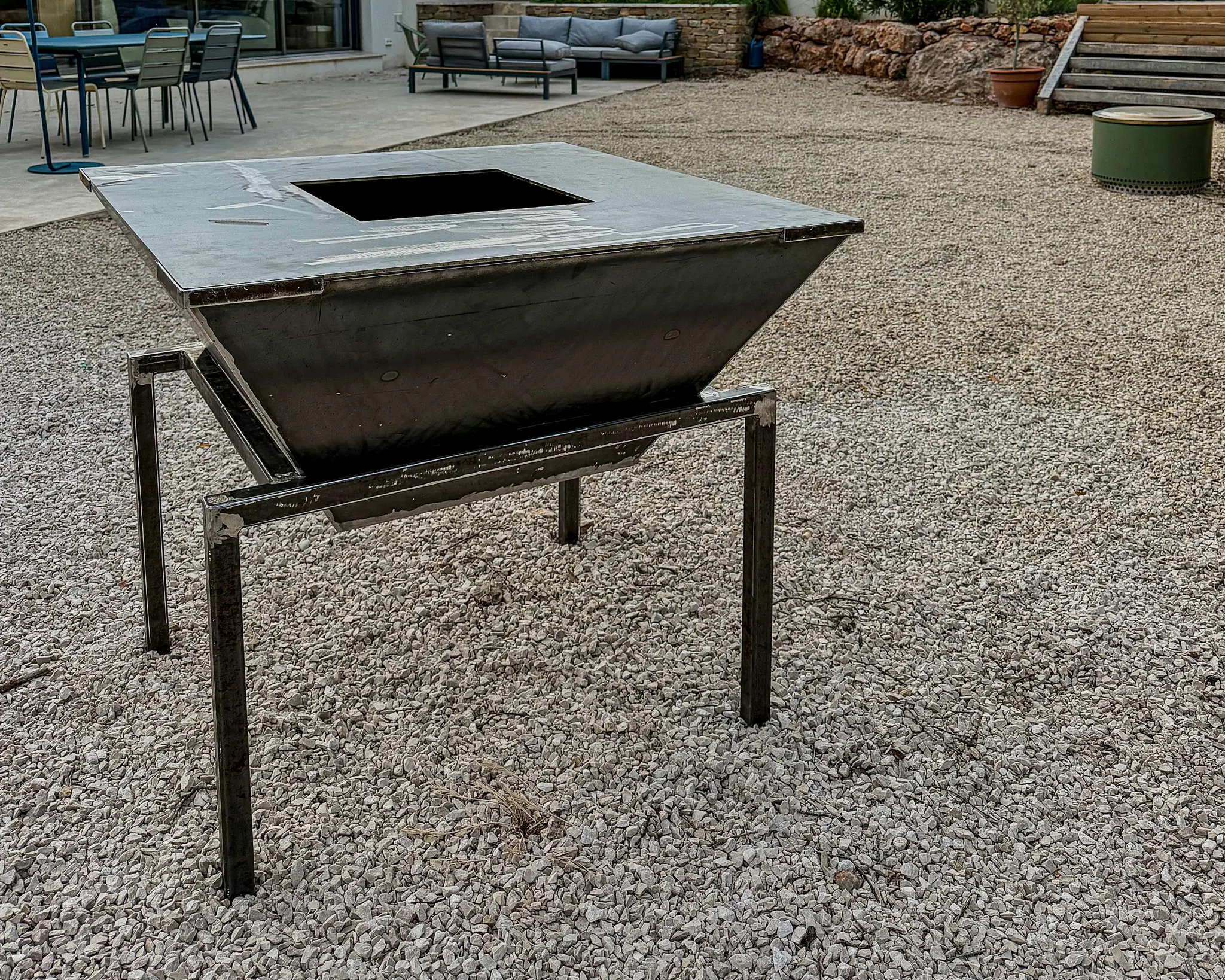 Brasero carré design et contemporain, fait sur mesure en métal avec une plaque de cuisson en inox pour un client à Trets, près d'Aix-en-Provence.