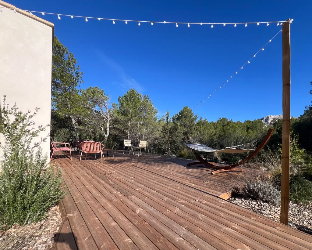 Création d'une terrasse en bois de pin sur mesure après terrassement, intégrant des massifs provençaux et un éclairage d'ambiance à Venelles